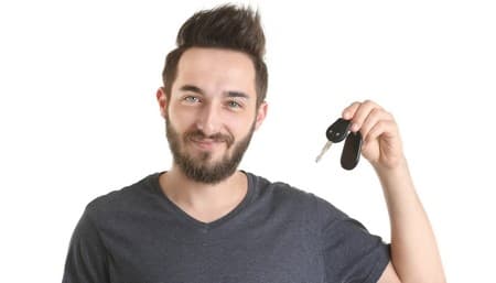Conducteur souriant devant sa voiture financée par un crédit auto